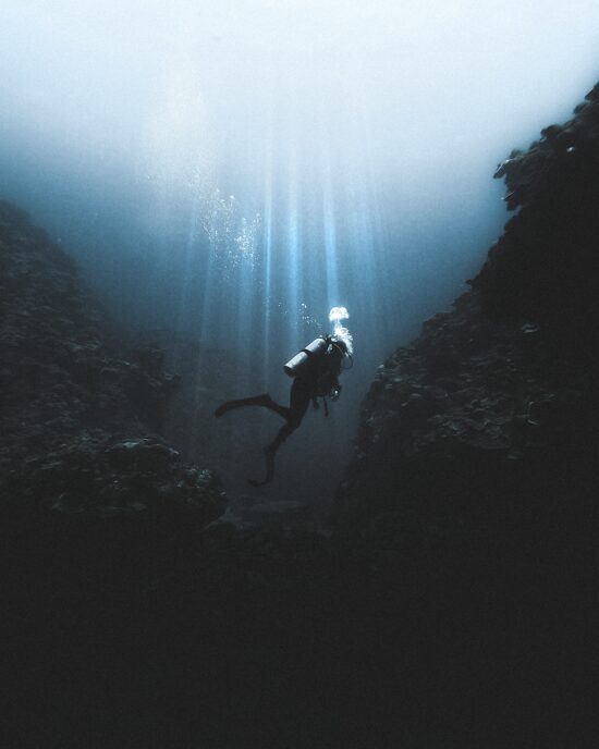 Scuba diver swimming near rocks